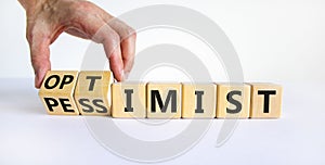 Pessimist or optimist symbol. Businessman turns cubes and changes the word `pessimist` to `optimist`. Beautiful white table, w