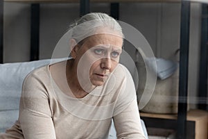 Pessimistic aged woman suffering from senile disease looking unhappy photo