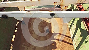 Pest control service workers doing fumigation in cargo hold of grain bulker ship. Men throw fumigant tablets into wheat