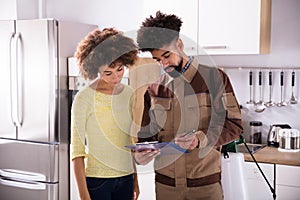 Pest Control Worker Showing Invoice To Woman