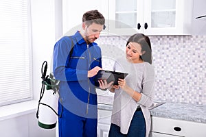 Pest Control Worker Showing Invoice To Woman