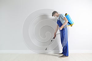 Pest control worker spraying pesticide. Space for text