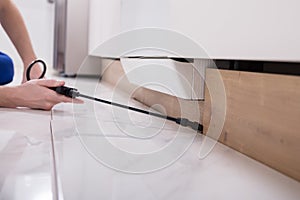 Pest Control Worker Spraying Pesticide On Wooden Cabinet photo