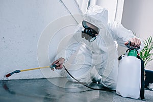 pest control worker spraying pesticides on floor