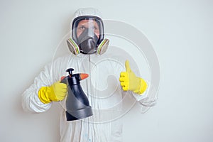 Pest control worker spraying pesticides with sprayer in apartment copy spase white walls background photo