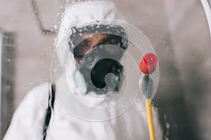 pest control worker standing in respirator in bathroom
