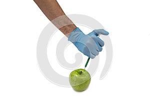 Pesticides and nitrates are injected into a apple with a syringe. Gmo concept