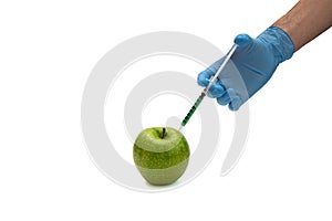 Pesticides and nitrates are injected into a apple with a syringe. Gmo concept