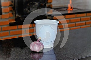 Pestle and garlic cup on table