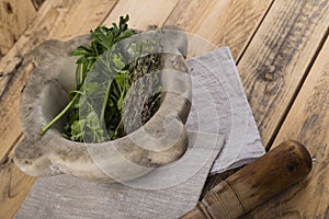 Pestle and mortar with herbs on table