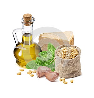 Pesto sauce ingredients, green basil leaves, garlic cloves, parmesan cheese, oil bottle and pine nuts in burlap bag isolated on