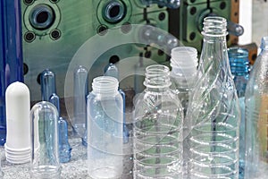 The PET bottles and the preform shape with the injection mould background.