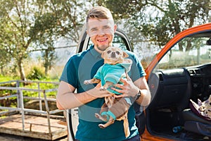 Pet, domestic animal, season and people concept - Portrait of happy man with his chihuahua dog walking outdoors