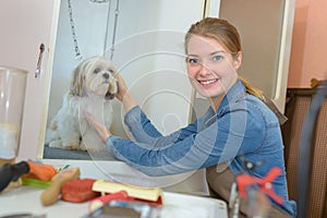 Pet groomer posing with dog