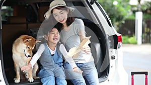 Pet lover And Asian family. Mother and child are playing a paper plane on a car with a beautiful view. The boy waved Mother and ch