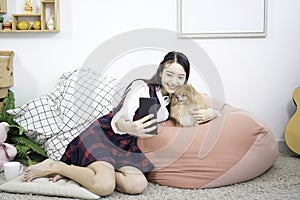 Pet Lover concept. A girl is selfie with a Pommerenian dog on a bed in a white Japanese-style living room