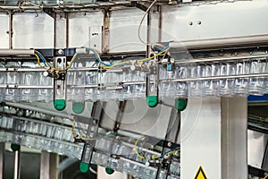 PET plastic bottles move on automatic conveyor line or belt in water factory or plant production, close up