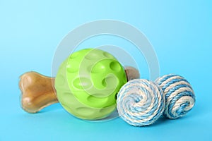 Pet toys and dog treat on light blue background