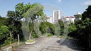Petaling Jaya, Malaysia - April 8, 2023 Moving up aerial view of a single tree at the empty parking lot.