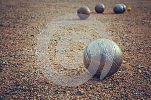 Petanque balls on a sandy pitch with other metal ball