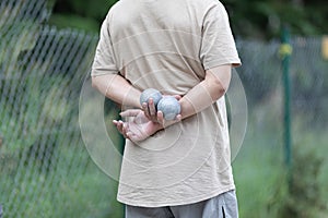 Petanque player holds the balls behind his back