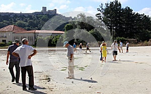 Petanque players on a sunny day, Obidos Castle in the background, Portugal