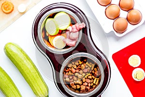 Petfood set with vegetables and eggs on kitchen table background
