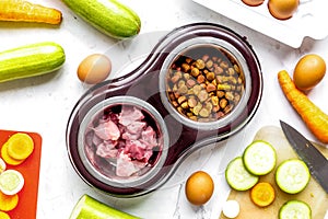 Petfood set with vegetables and meat on kitchen table background top view