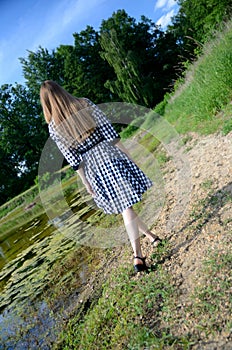 Petite woman wearing dress at lake