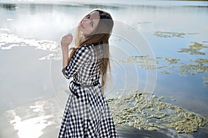 Petite woman wearing dress at lake