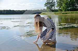 Petite woman wearing dress at lake