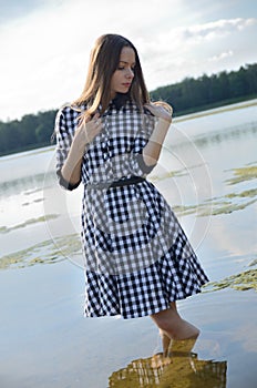 Petite woman wearing dress at lake