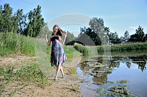 Petite woman wearing dress at lake