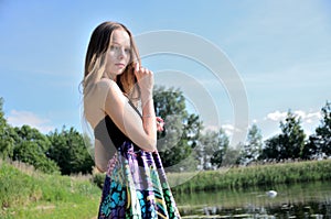 Petite woman wearing dress at lake