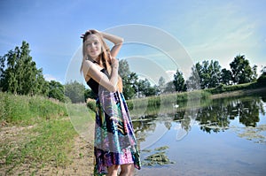 Petite woman wearing dress at lake