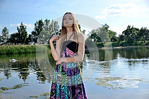 Petite woman wearing dress at lake