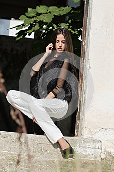Petite young woman with very long hair wear heels and white pants
