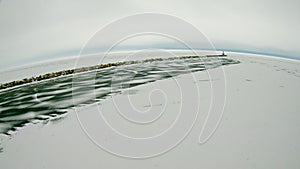 Petoskey Harbor Breakwater in spring with frozen lake