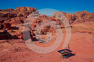 Petra, carving building and red mountains landscape.