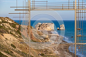Petra tou Romiou, Aphrodite`s birthplace in Paphos, Cyprus behind a framed construction