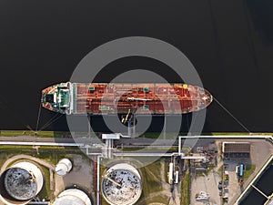 Petrochemical energy heavy transport industry cargo vessel tanker top down aerial drone view. Docked bulk carrier ship