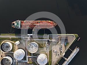 Petrochemical energy heavy transport industry cargo vessel tanker top down aerial drone view. Docked bulk carrier ship