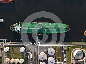 Petrochemical energy heavy transport industry cargo vessel tanker top down aerial drone view. Docked bulk carrier ship