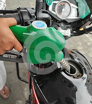 Petrol fuel refill in a bike by a petrol pump station worker