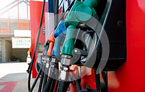 Petrol pump filling fuel nozzle in gas station. Fuel dispenser. Refuel fill up with petrol gasoline. Gas pump handle. Green petrol