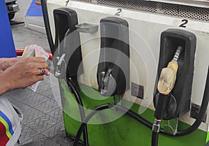 Petrol pump filling nozzles at a gas station in Indonesia