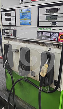 Petrol pump filling nozzles at a gas station in Indonesia