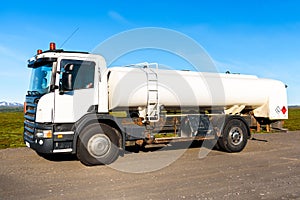 Petrol tanker truck on a gravel road at sunset