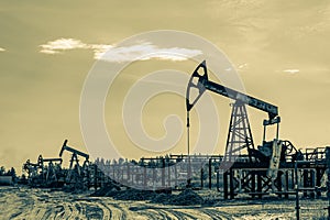 Petroleum concept. Oil pump rig. Oil and gas production. Oilfield site. Pump Jack are running. Drilling derricks for