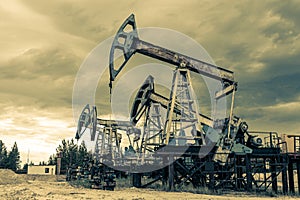 Petroleum concept. Oil pump rig. Oil and gas production. Oilfield site. Pump Jack are running. Drilling derricks for
